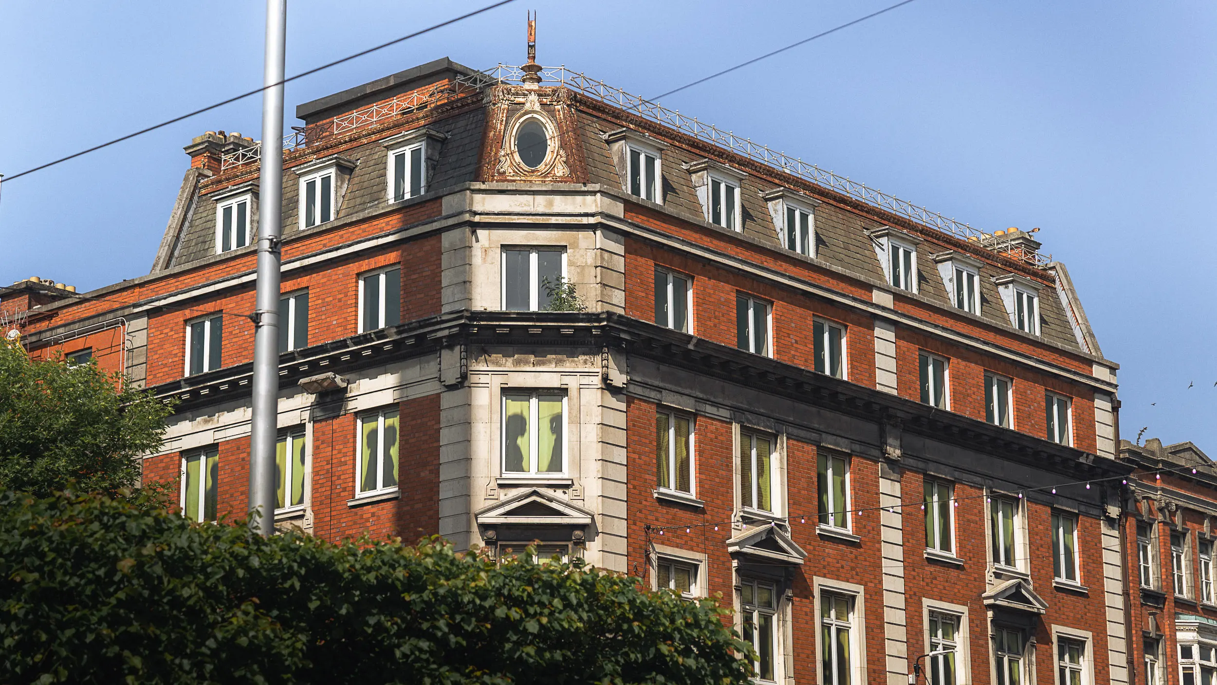 Historic Dublin building with window silhouettes of people, illustrating the lively atmosphere and charming architecture common in the city’s older neighborhoods and accommodation areas.