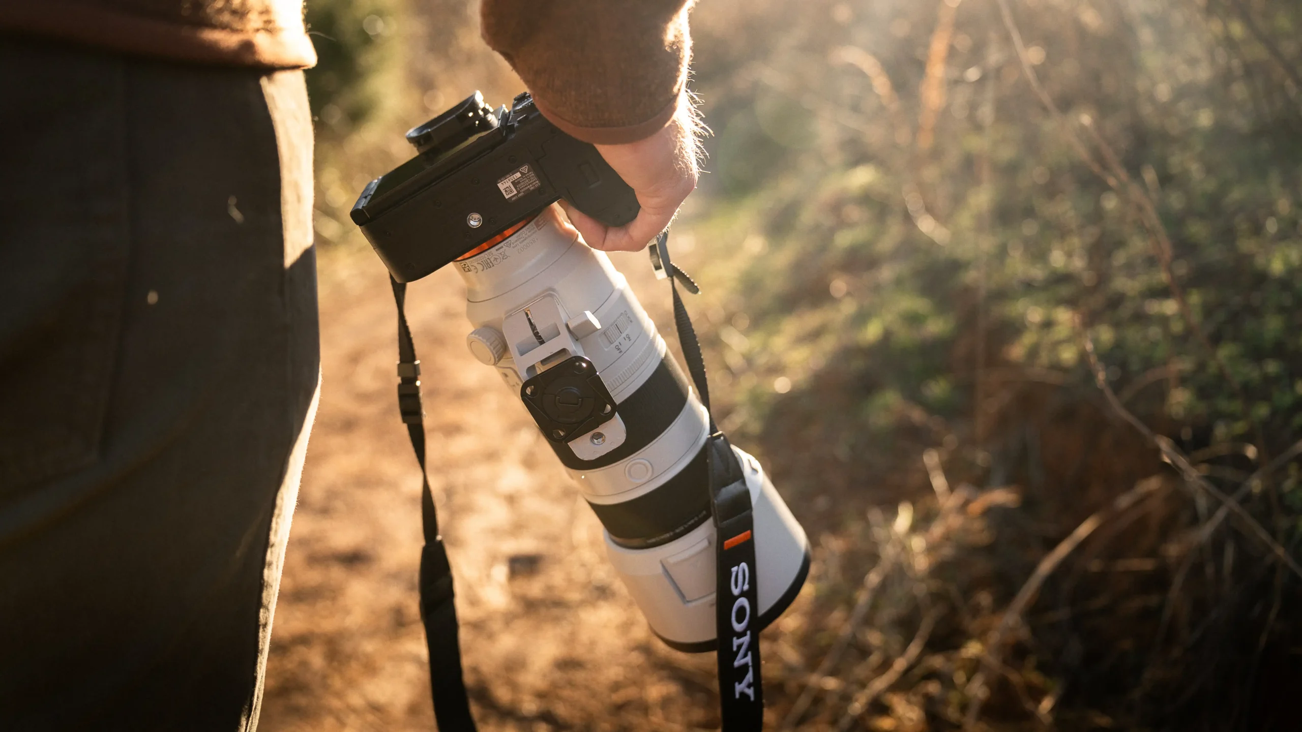 Demonstrating the comfortable grip of the Sony A7 V camera while holding it one-handed outdoors