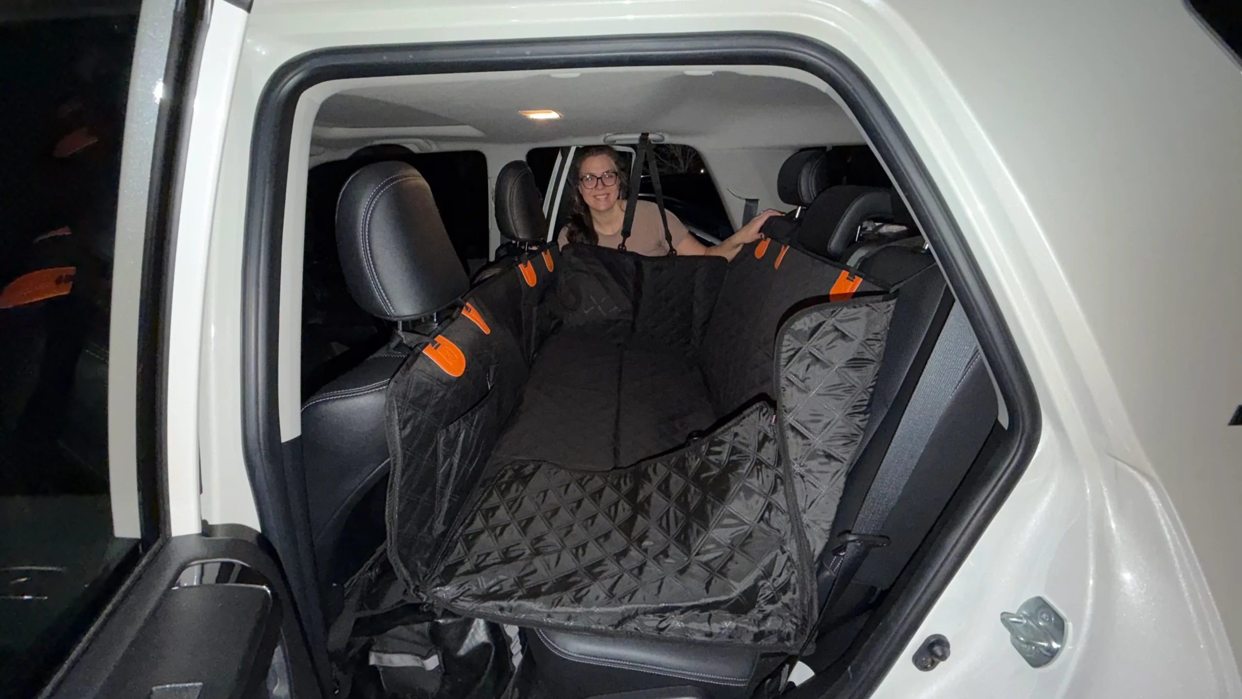 Assembling a hard-bottom dog seat cover inside a car during full-time travel with dogs